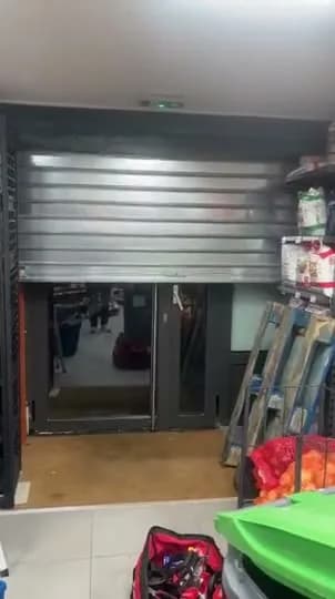 Ouverture d’un rideau métallique galvanisé motorisé devant la porte d’un magasin
