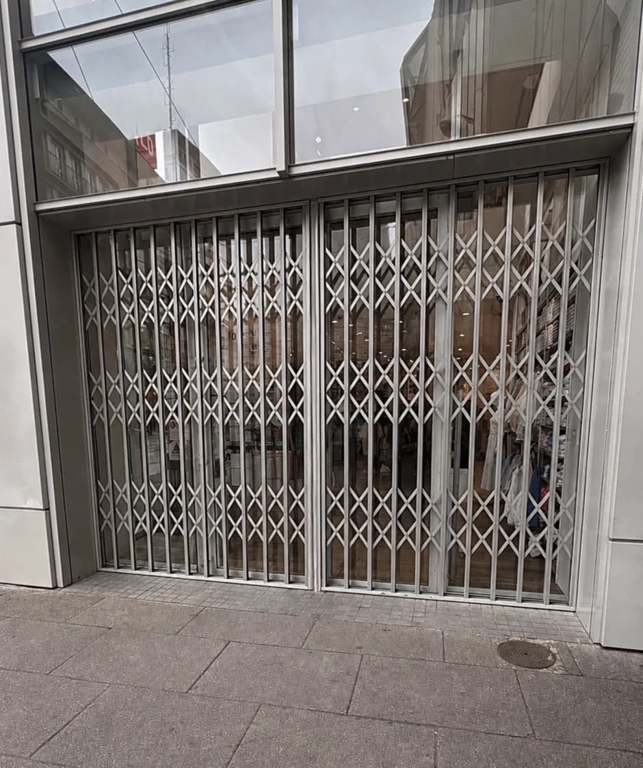 Grille extensible fermée devant la vitrine d’une boutique