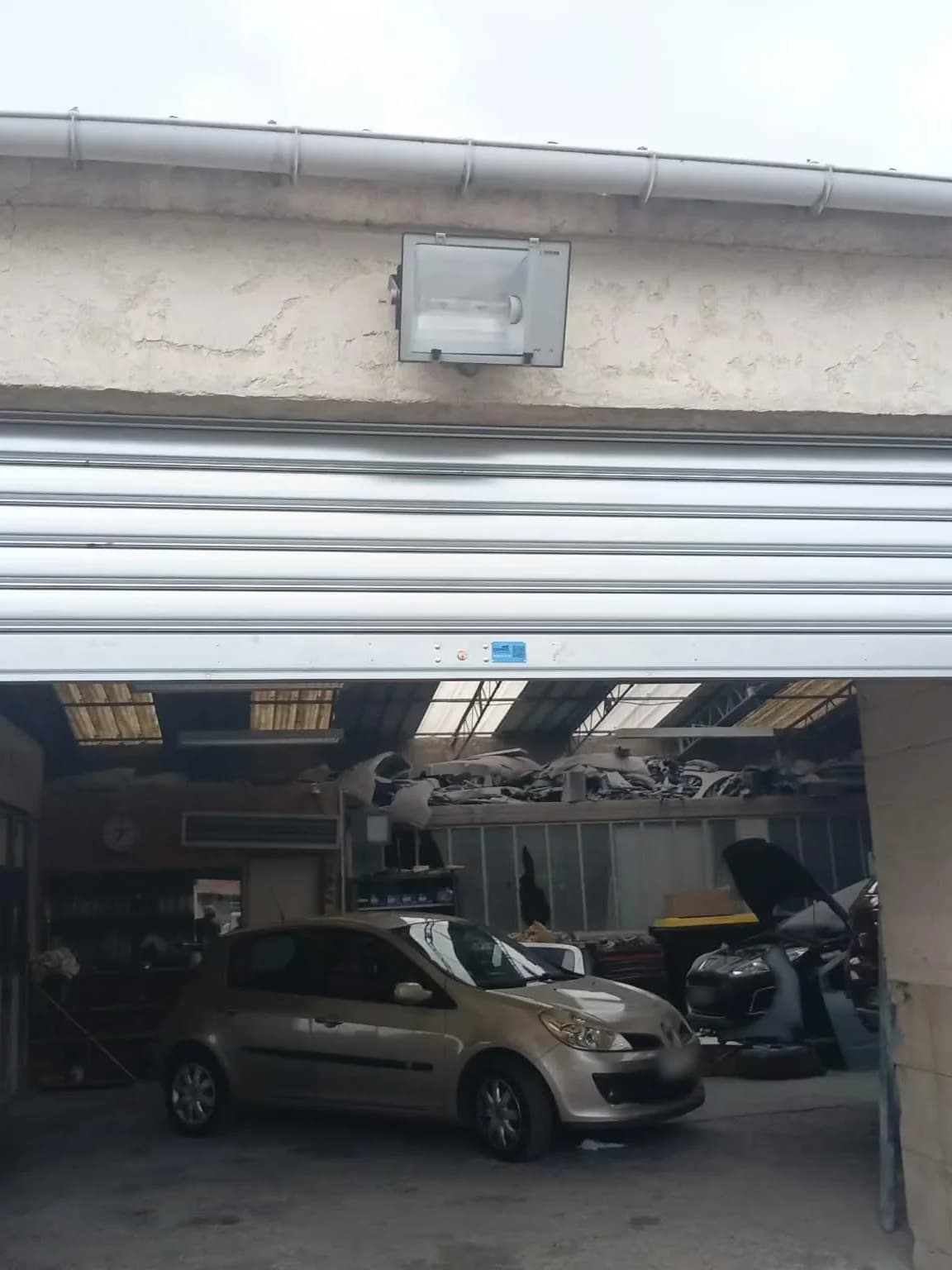 Rideau métallique neuf ouvert sur un atelier de garage automobile