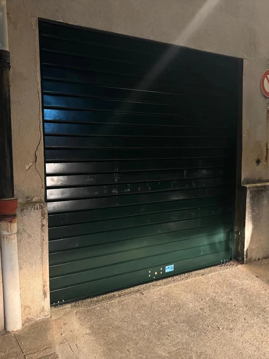 Rideau métallique de garage posé sur une façade donnant sur rue